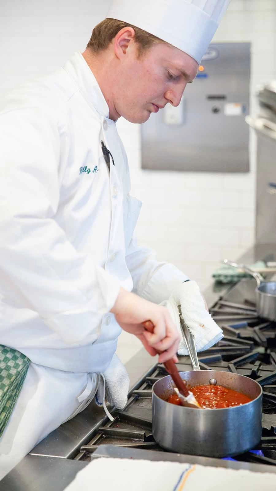 Chef in the kitchen of the Gatehouse Restaurant at The Culinary Institute of America at Greystone.